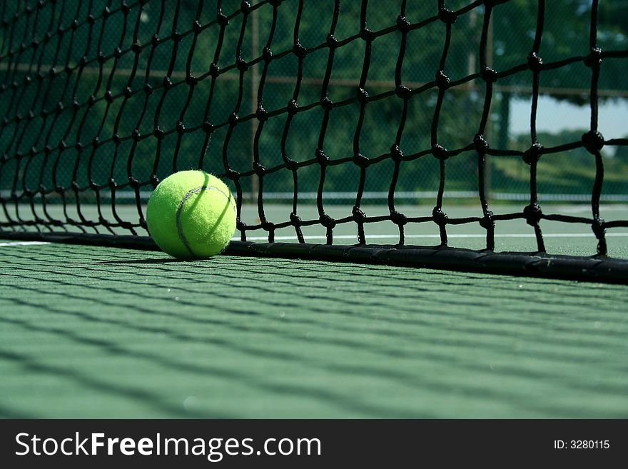 A Tennis ball near net with showdows