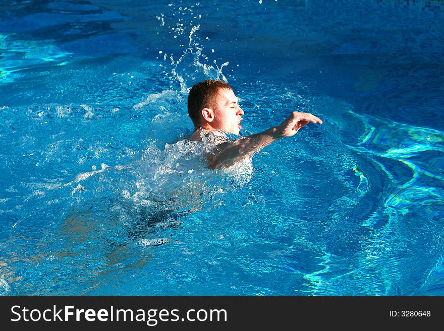 Young man swimming in the pool