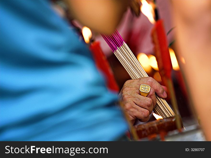 Seeking prosperity through prayers. The Chinese character depicted on the golden ring means prosper and reinforces the religious intent of the worshiper.