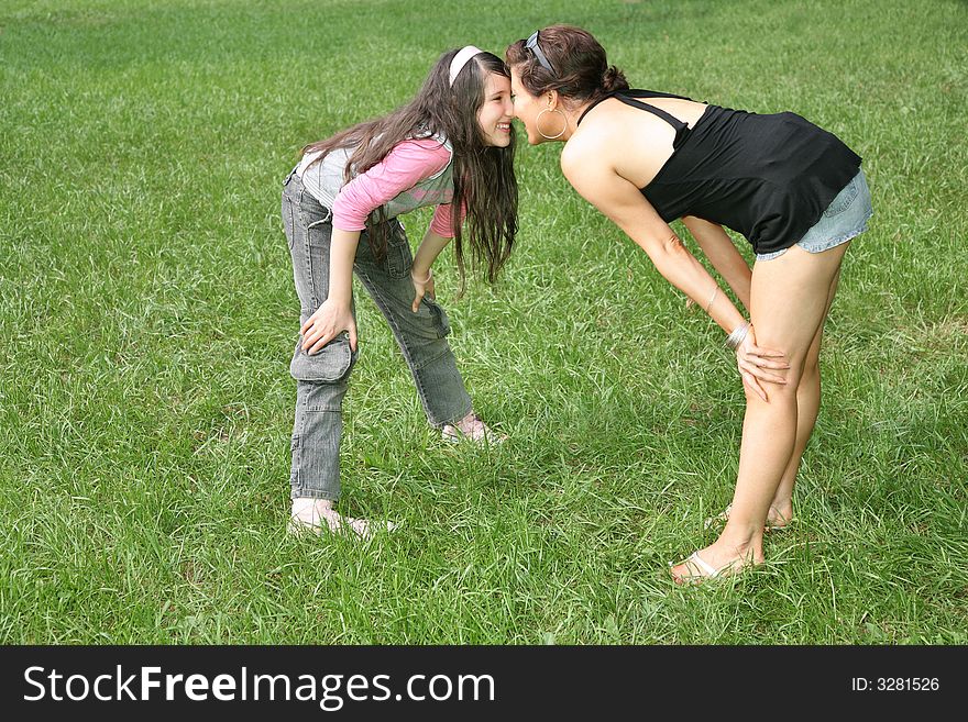 Mother and daughter stand on the grass