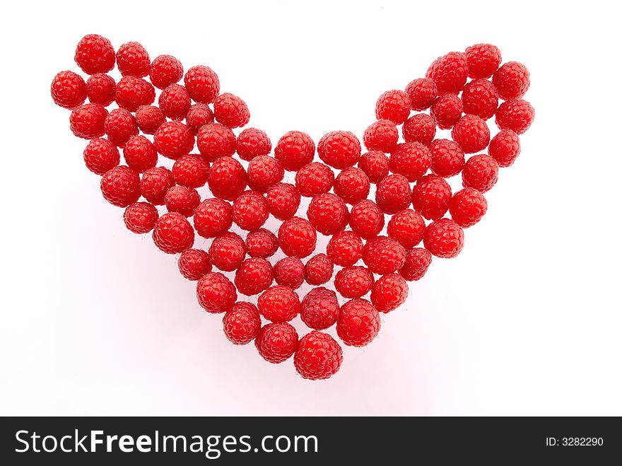 Berries of  red raspberry  hearts laid out as  symbol, love and Valentine. Berries of  red raspberry  hearts laid out as  symbol, love and Valentine