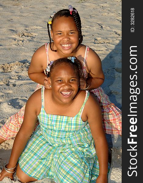 Two african american sisters posing outside on a beach. Two african american sisters posing outside on a beach