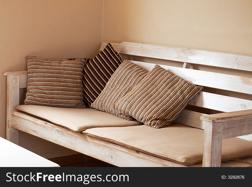 White wooden couch with cushions on it inside the house