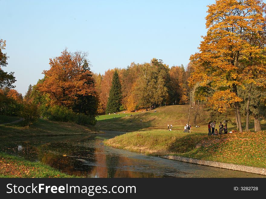 Picturesque autumn landscape of river and bright trees and bushes