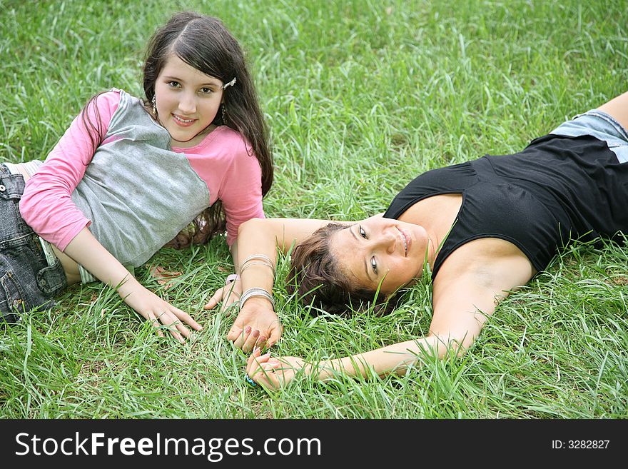 Mother and daughter-teenager lie on the grass 2