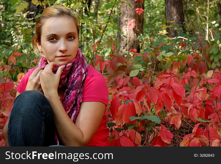 Thoughtful girl sitting in colorful autumn forest. Thoughtful girl sitting in colorful autumn forest
