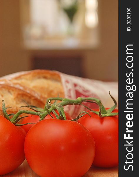 Upright of tomatoes and bread with sunny window behind. Upright of tomatoes and bread with sunny window behind
