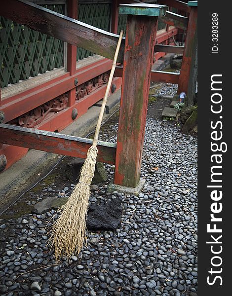 A broom rests on a porch in japan. A broom rests on a porch in japan