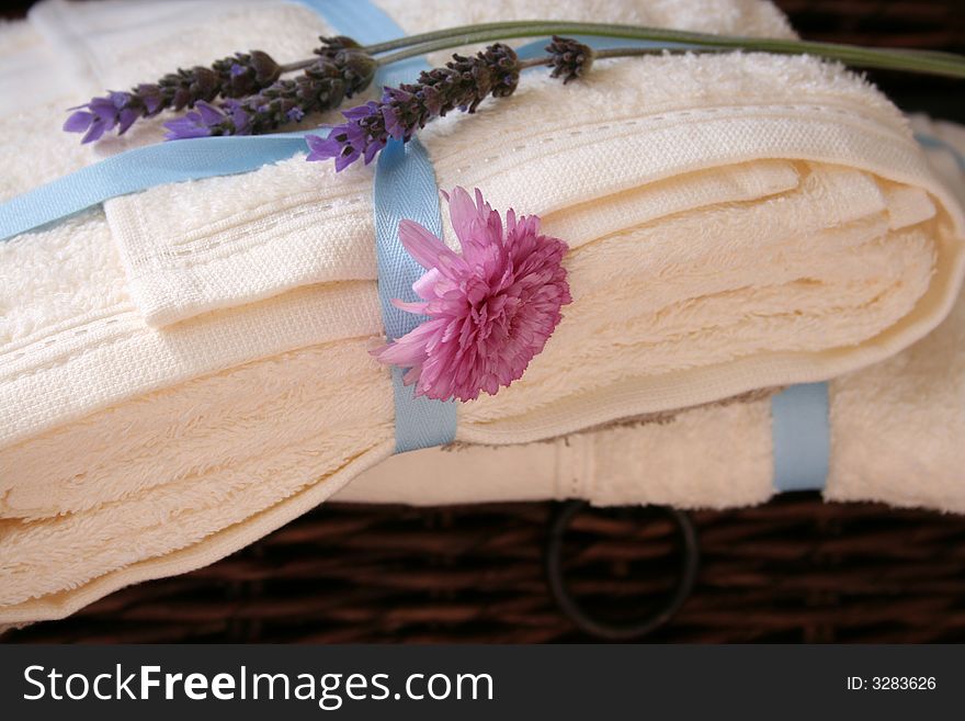 Pile of towels in a drawer with fresh flowers ontop