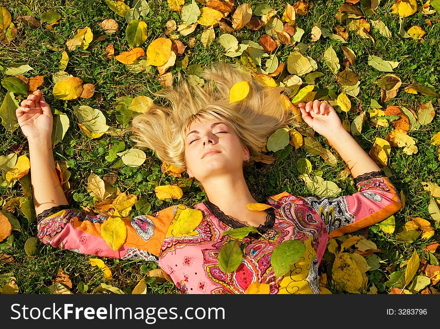 Beautiful blond girl lying on autumn leaves. Beautiful blond girl lying on autumn leaves