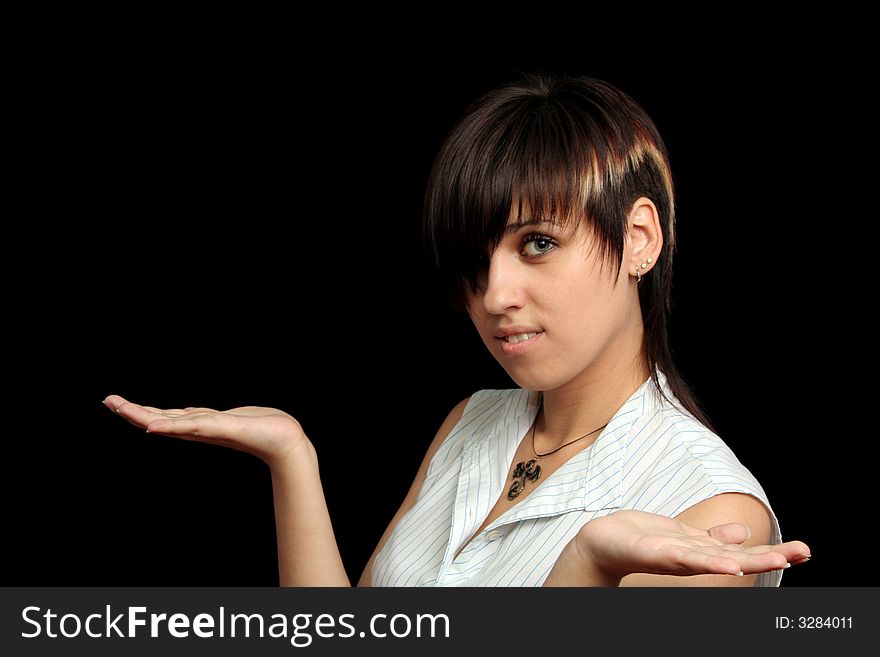 The young girl holds something in a hands, isolated on a black background. The young girl holds something in a hands, isolated on a black background