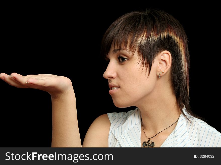 The young girl holds something in a hands, isolated on a black background. The young girl holds something in a hands, isolated on a black background