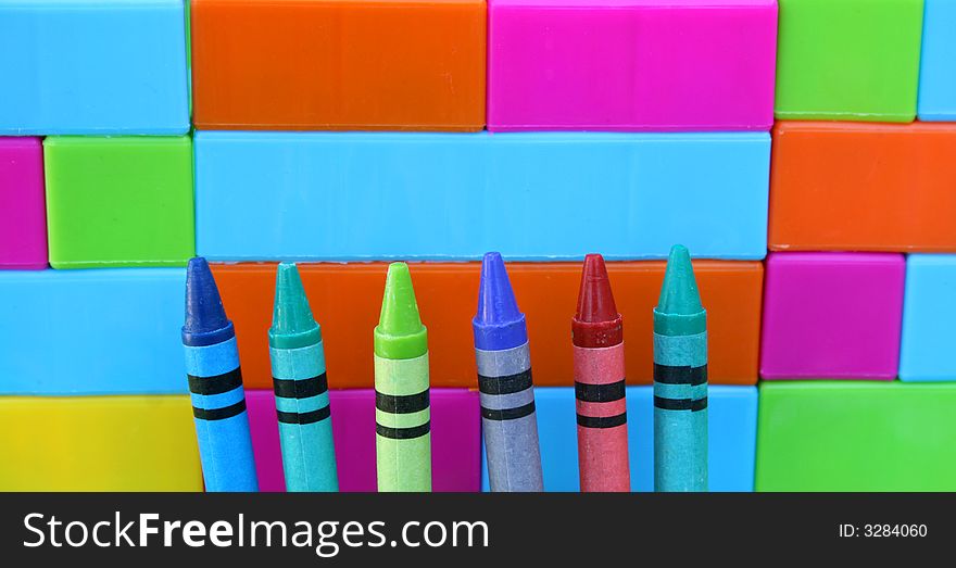 Six crayon tips against a building blocks wall