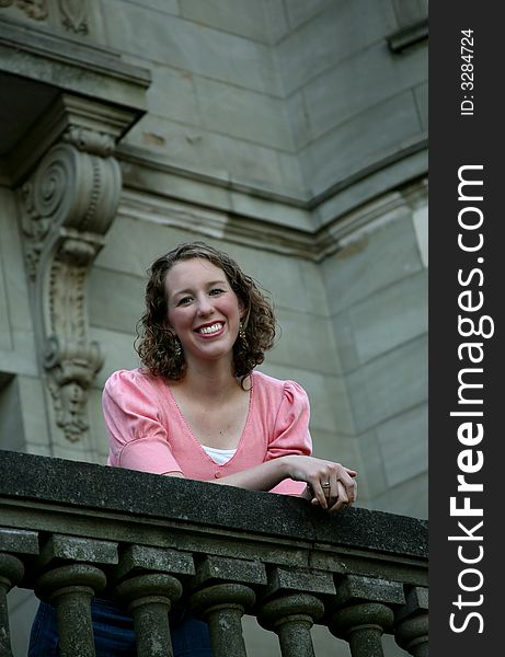 Image of a teenage girl on the balcony of an old building