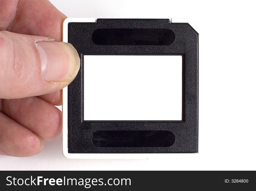 A hand holding a film slide, the centre portion of the slide is blank so an image can be inserted. A hand holding a film slide, the centre portion of the slide is blank so an image can be inserted