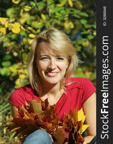 The beautiful girl with leaves of a maple