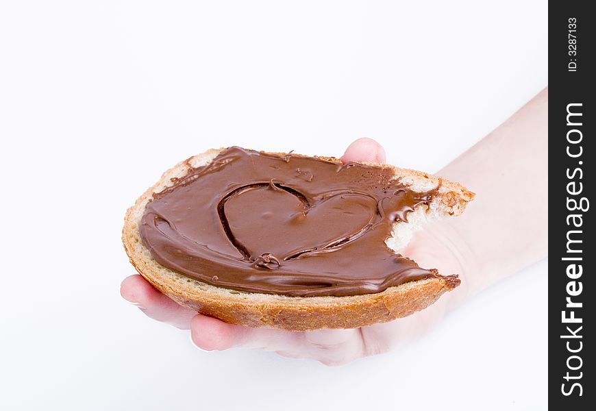 Slice of bread with choco paste in hand on the white background