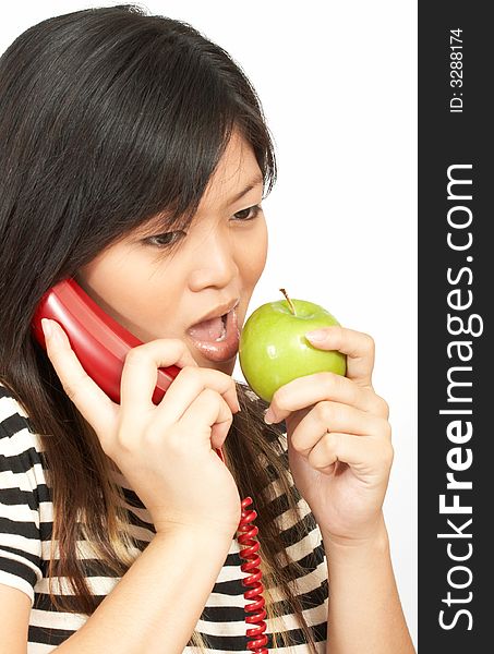 A woman eating an apple while on the phone. A woman eating an apple while on the phone