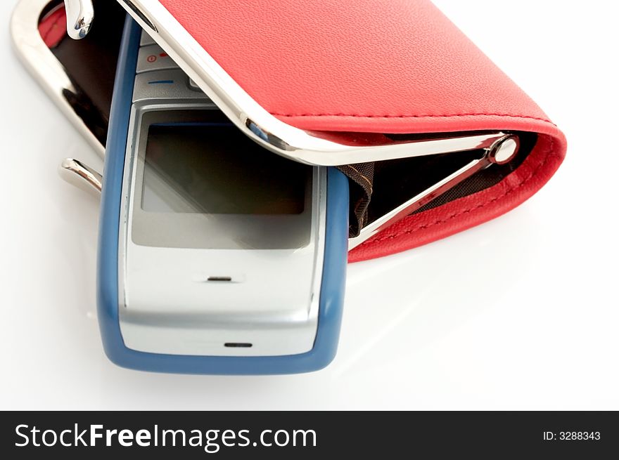 A mobile phone inside a red wallet over a white background. A mobile phone inside a red wallet over a white background