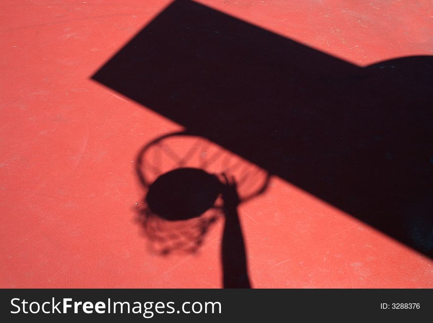 A Shadow Basketball player dunking on red court