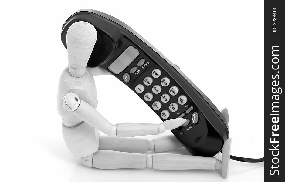 Wooden figure holding a black telephone over a white background