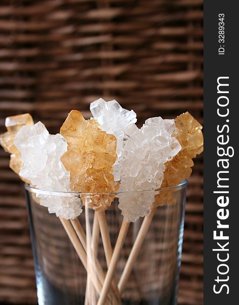 Sugar crystals on wooden sticks in a glass container. Sugar crystals on wooden sticks in a glass container