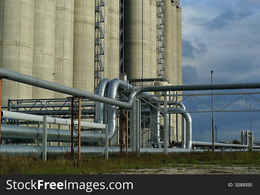 Pipes bridges and concrete silos against blue sky