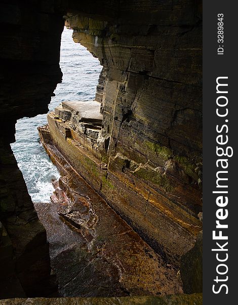 Eroded hole in sandstone cliffs in Orkney. Eroded hole in sandstone cliffs in Orkney