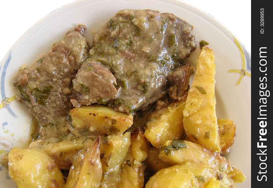 Beef with potatoes on a white plate, isolated. Beef with potatoes on a white plate, isolated