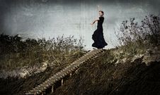 Enigmatic Woman In Black Dancing In The Dunes, On The Top Of The Stairs Royalty Free Stock Images Enigmatic Woman In Black Dancing In The Dunes, On The Top Of The Stairs Royalty Free Stock Images