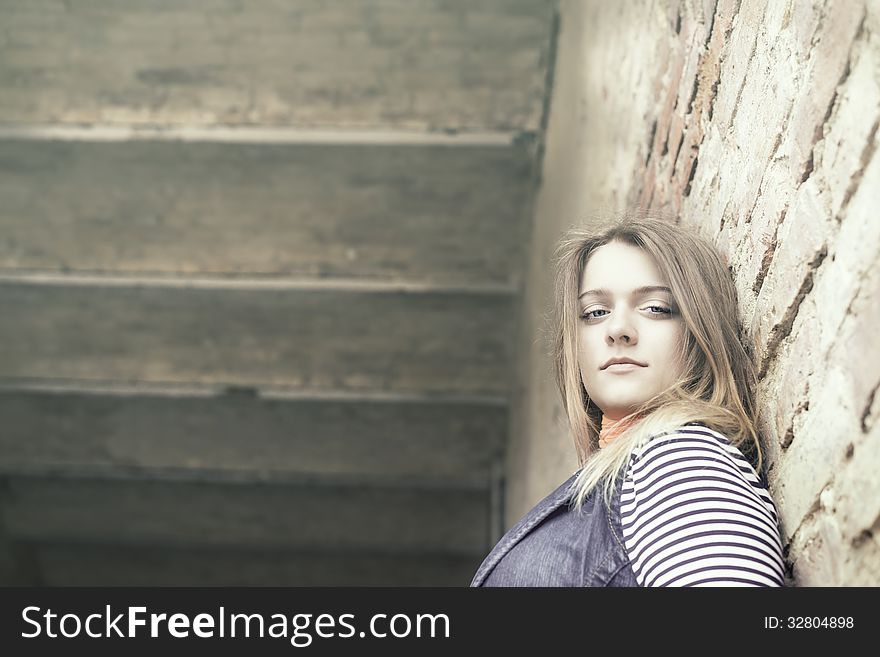 Beautiful Girl Outdoor Against A Concrete Wall