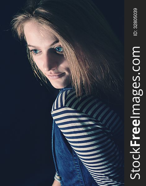 Portrait of beautiful thoughtful girl close up in the dark