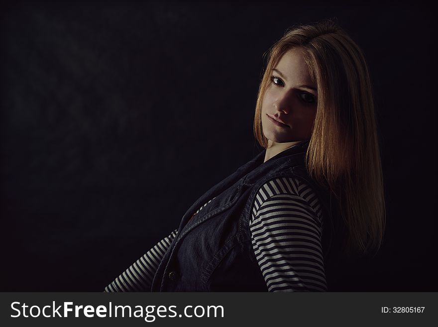 Portrait of beautiful thoughtful girl close up in the dark