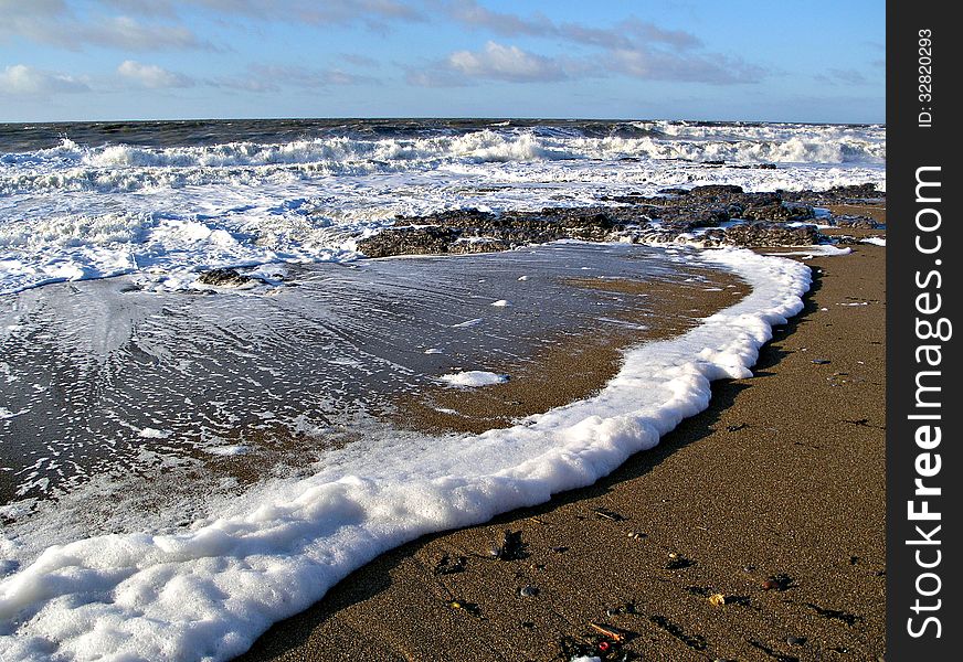 Foamy waves coming in on the beach at Porthcawl. Foamy waves coming in on the beach at Porthcawl