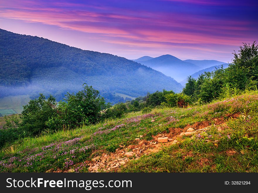View of the mountains in the fog in the morning standing on a hillside. View of the mountains in the fog in the morning standing on a hillside