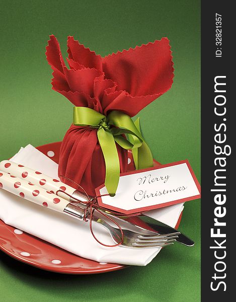 Traditional red and green Merry Christmas dinner or lunch table place setting with individual gift wrapped plum pudding. Vertical. Traditional red and green Merry Christmas dinner or lunch table place setting with individual gift wrapped plum pudding. Vertical.