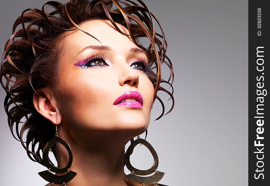 Closeup face of the beautiful woman with fashion creative hairstyle and glamour makeup poses at studio. Closeup face of the beautiful woman with fashion creative hairstyle and glamour makeup poses at studio.