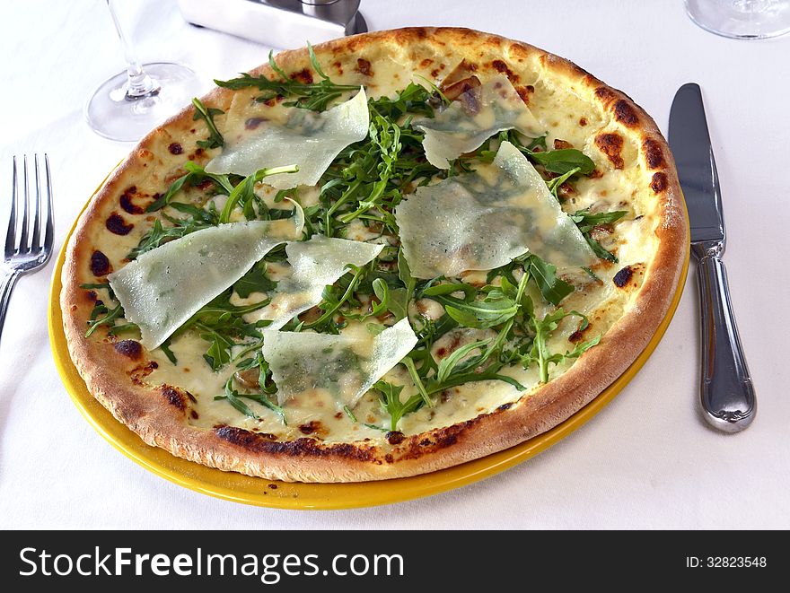 Pizza with mushrooms and parmesan cheese on a table in a restaurant