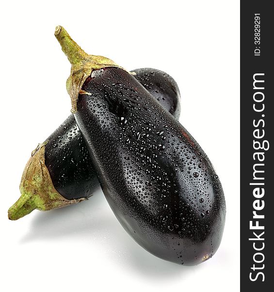 Aubergines with drops of water on a white background