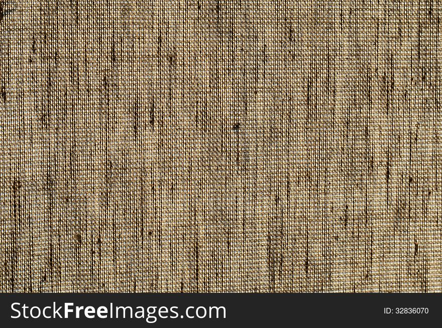 Rough light brown burlap fabric on a light background close-up. Rough light brown burlap fabric on a light background close-up