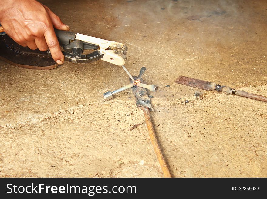 Welder man welding steel on cement floor with spread spark