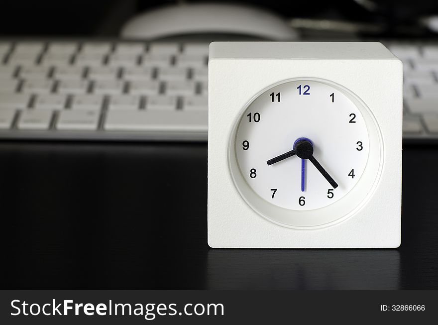 White clock, keyboard, business table in the office