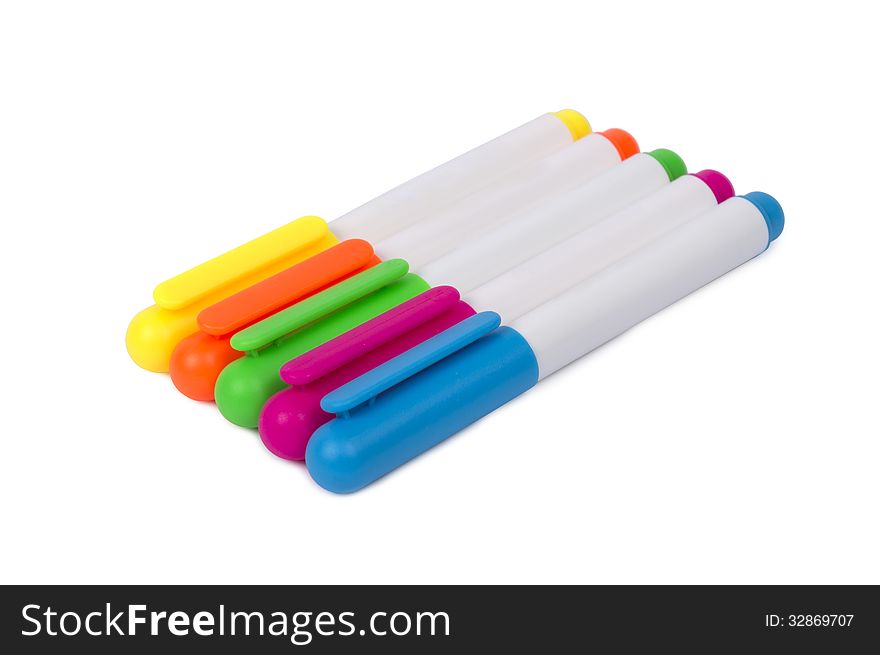 Row of colorful highlighters shot horizontally and isolated on a white background. Focus on the front. Row of colorful highlighters shot horizontally and isolated on a white background. Focus on the front.
