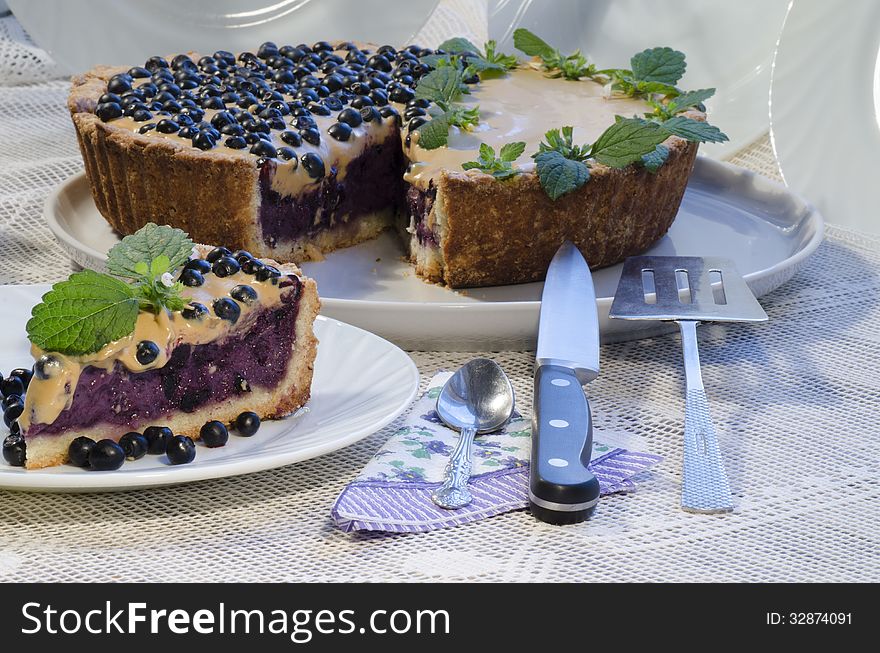 Slice of blueberry pie with mint served with knife and paddle for cake