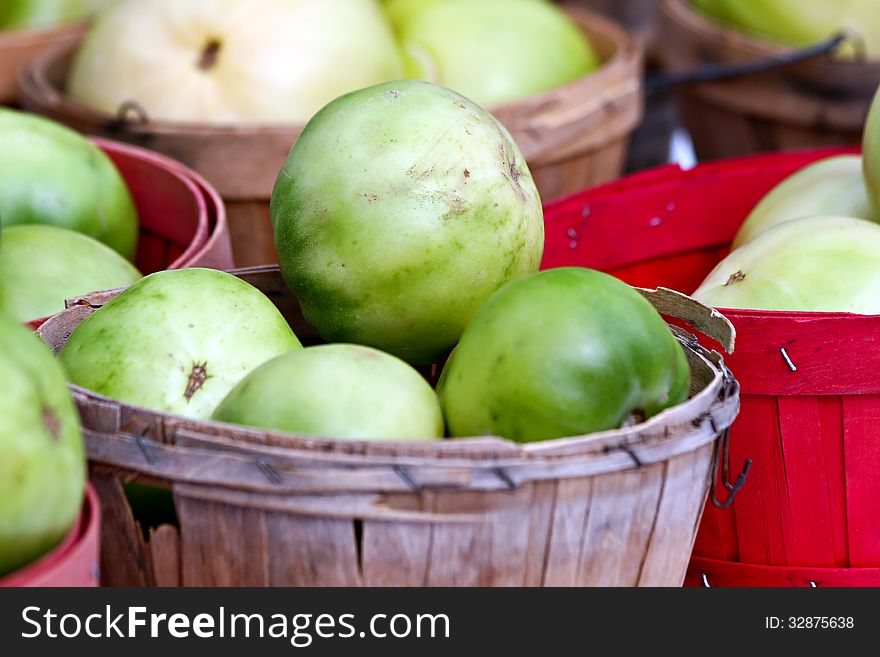 Basket of green tomatoes at the farmer's market.