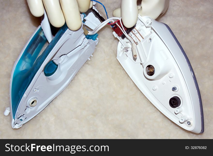 Disassembled iron has two main parts due to electricity special rubber gloves protect person