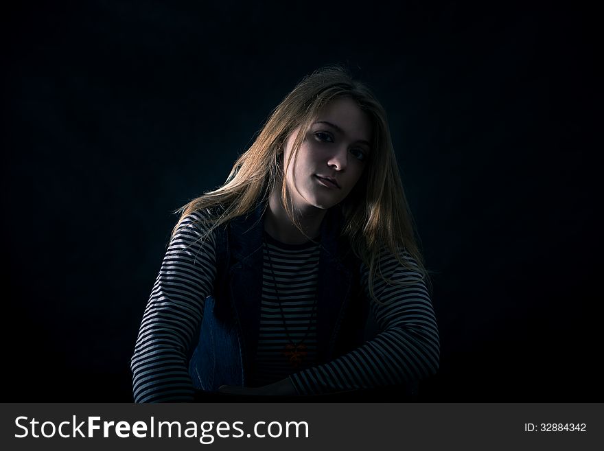 Portrait of beautiful thoughtful girl close up in the dark