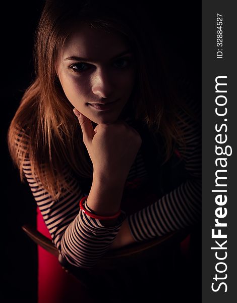 Portrait of beautiful thoughtful girl close up in the dark