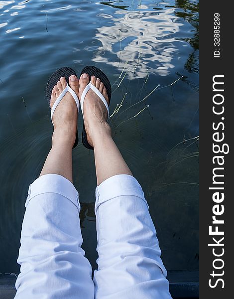 Female's feet with flip flop and white capri pants. Female's feet with flip flop and white capri pants.