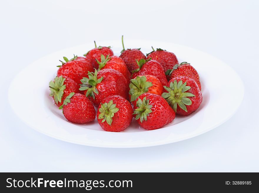 Fresh red ripe strawberries on a white plate. See my other works in portfolio.